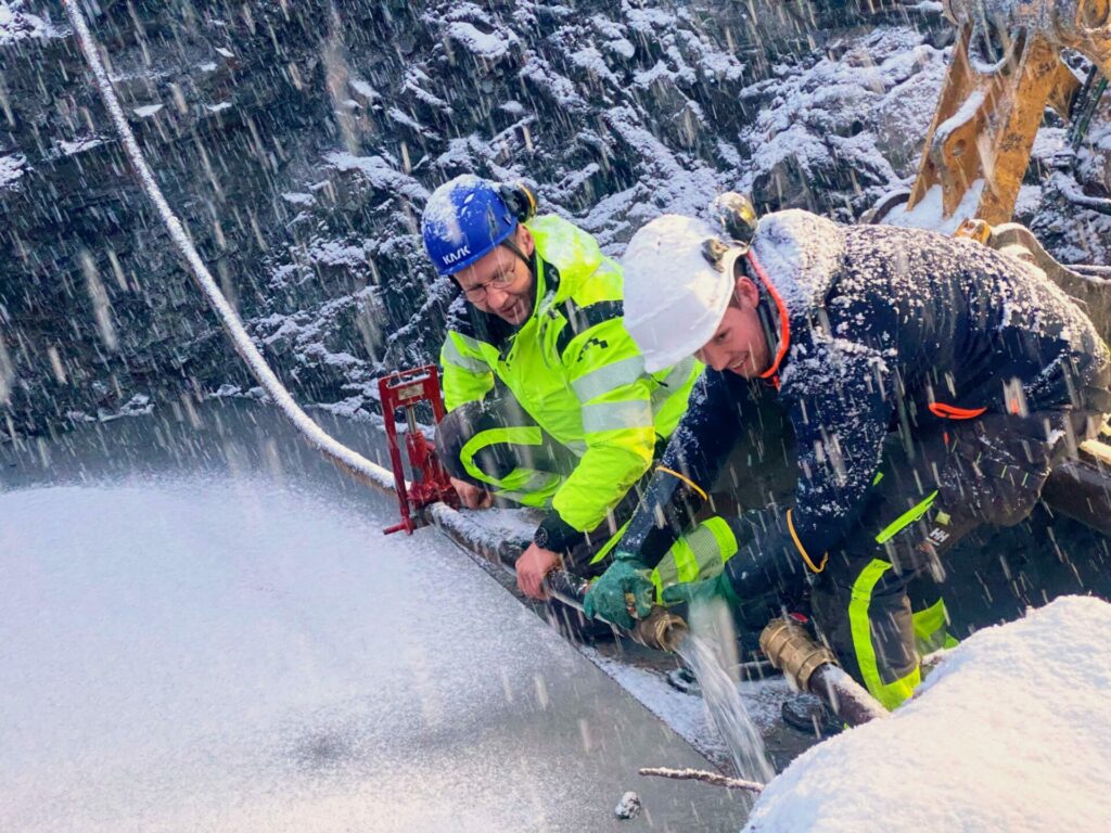 Odd Magne Kartfjord og Andreas Arctander kobler om eksisterende vannrør. Foto: Inger Unstad