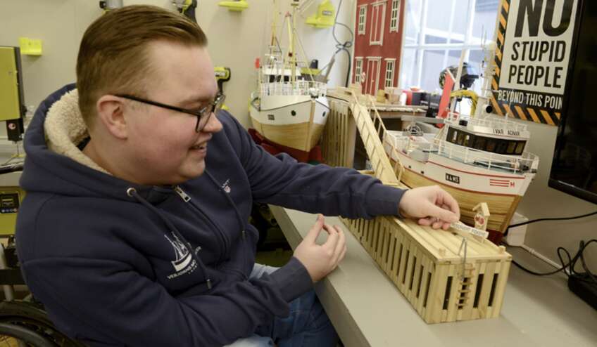 Vebjørn legger siste hånd på verket; et skilt som gjør det klart at det først og fremst er fiskernes båter interessen hans handler om.