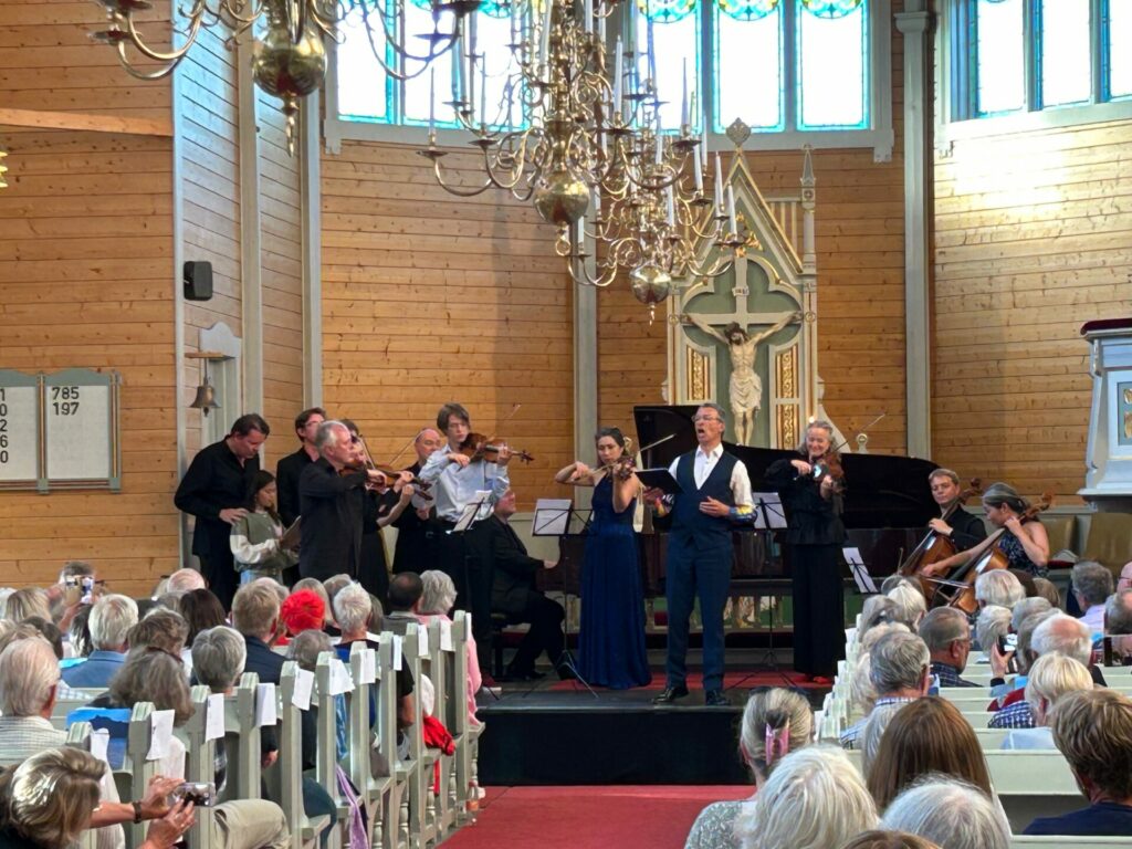 Baryton Roderick Williams med en rekke musikere på scenen under et innslag i Buksnes kirke lørdag: Foto: Eirik Husøy